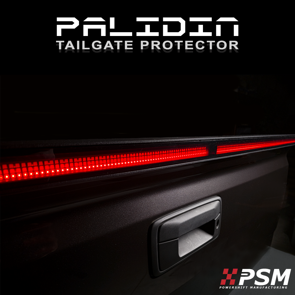 Close up PSM PALADIN LED tailgate protector on a truck tailgate in a studio with bright red high intensity LED's activated